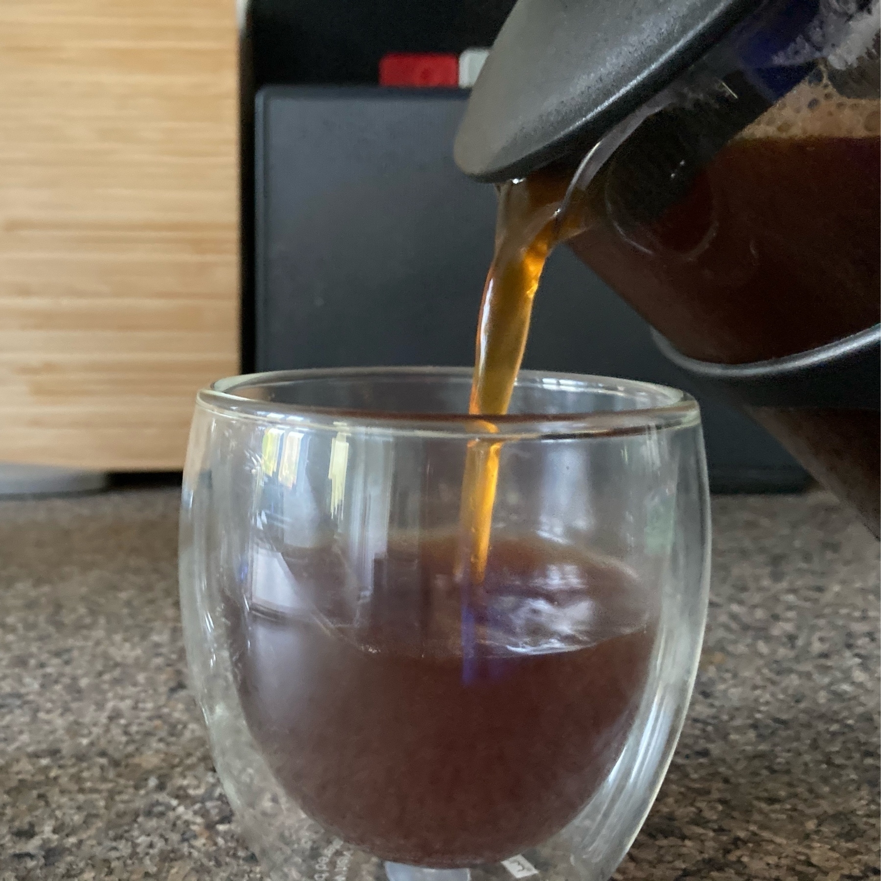 Coffee being poured into a glass.